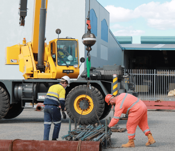 A Saferight Dogging course instructor assisting a course trainee load a stack of scaffold at a Saferight facility.