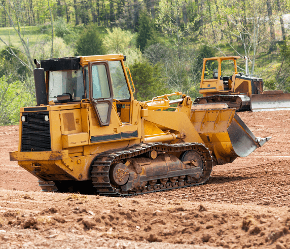 Dozer Ticket Perth / Bulldozer Licence Perth - Dozer in Operation. Conduct Civil Construction Dozer Operations. Two yellow bulldozers operating on a construction site with greenery in the background