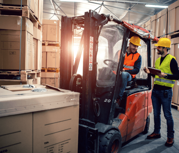 Forklift operator working on moving pallet boxes in a warehouse