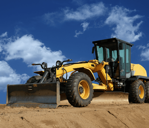 A grader on a construction site with a blue sky background doing the Conduct Civil Construction Grader Operations / Grader Ticket Perth / Grader Operator Training Course