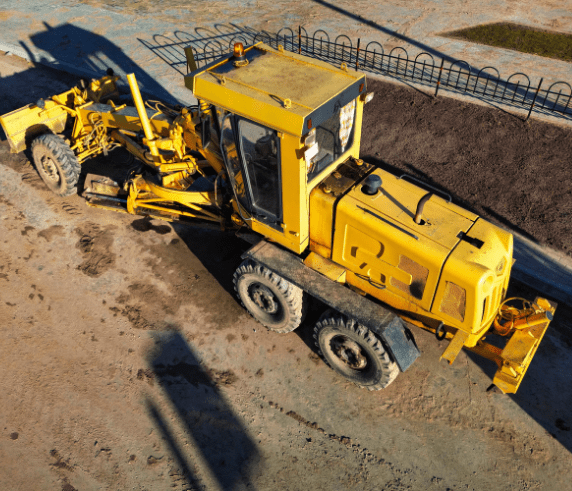 Conduct Civil Construction Grader Operations. Overhead view of a yellow construction grader operating in a construction site area.