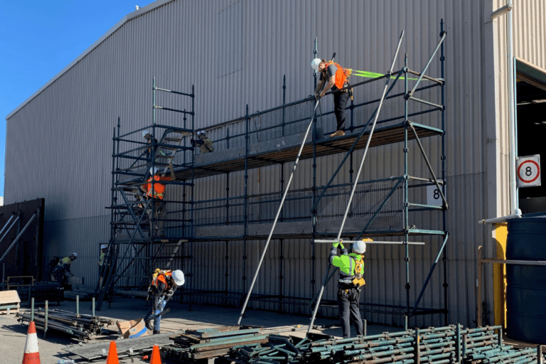 Saferights Basic Saffolding Ticket / Intermediate Scaffolding Course in Perth WA Trainees constructing a scaffold against a warehouse wall.