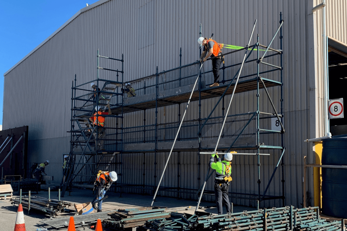 Saferights Basic Saffolding Ticket / Intermediate Scaffolding Course in Perth WA Trainees constructing a scaffold against a warehouse wall.