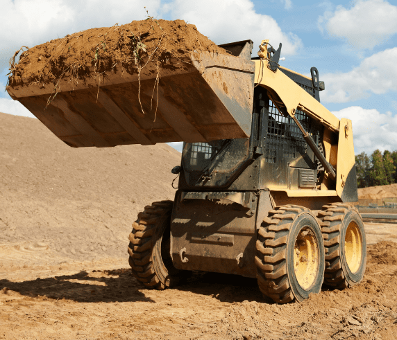 conduct civil construction skid steer loader operations. Skid steer loader lifting a full bucket of earth on a construction site