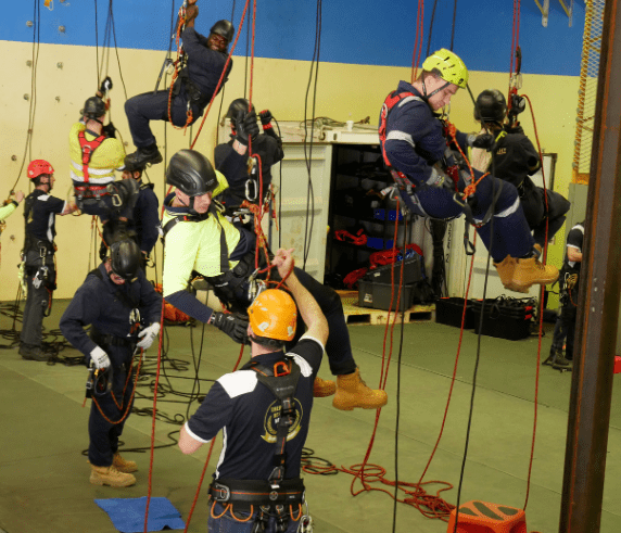 Student performing harness inspection during the Harness Course in Perth. Trainees practicing safety inspections on height safety equipment during an indoor training course at Saferight training facility.