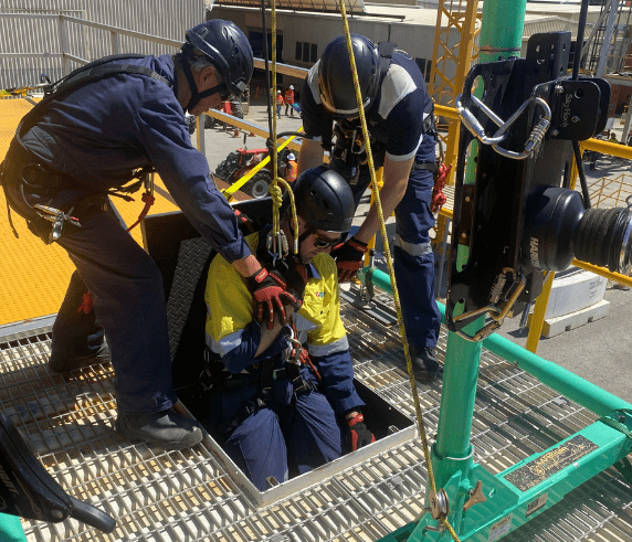 Confined Space Entry. Trainee in protective gear descending into a confined space during a supervisor training course