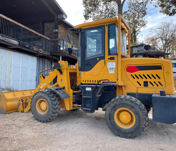 Conduct Civil Construction Wheeled Front End Loader Operations. Orange wheeled front-end loader with a large bucket, ready for operation on a civil construction site