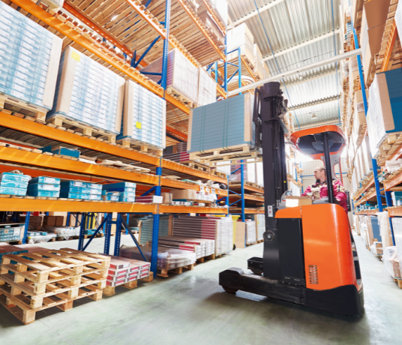 Order Picker Forklift Licence in Perth WA. An order picker forklift in a warehouse, with the operator inside the vehicle platform. The forklift is lifting goods from high shelves, surrounded by stacked pallets and warehouse shelving, showcasing a typical order picking process